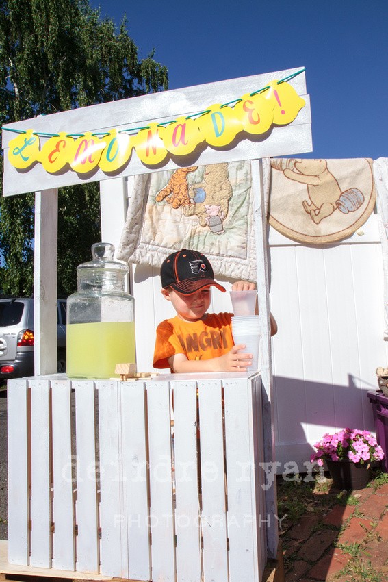 Little boy sells lemonade to buy a Lego set. Photo by Deirdre Ryan Photography.