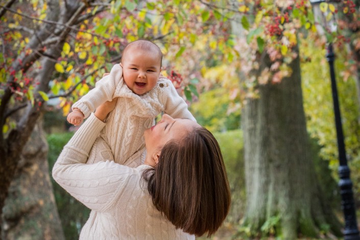 Mother and baby laughing together in the fall.