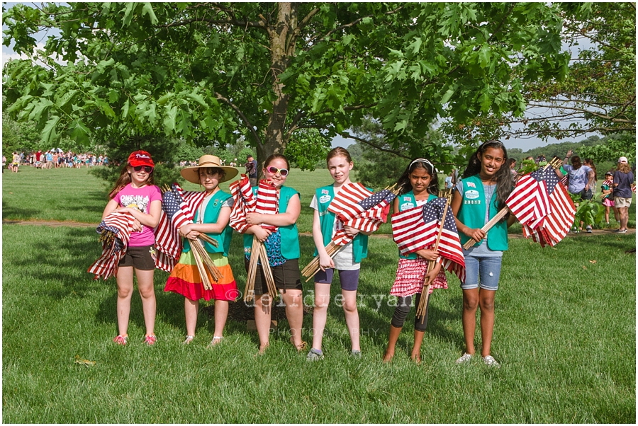 Girl Scouts placing American flags on graves on military for Memorial Day at Brigadier General Doyle Cemetary 