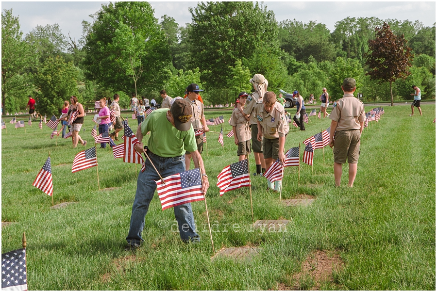 Girl Scouts placing American flags on graves on military for Memorial Day at Brigadier General Doyle Cemetary 